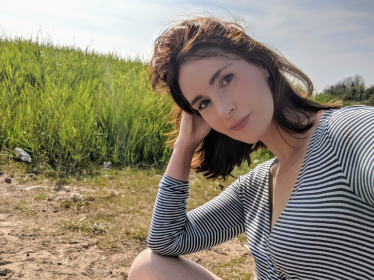 Bernadette Mcbride looks to the camera with a field of grass behind her.