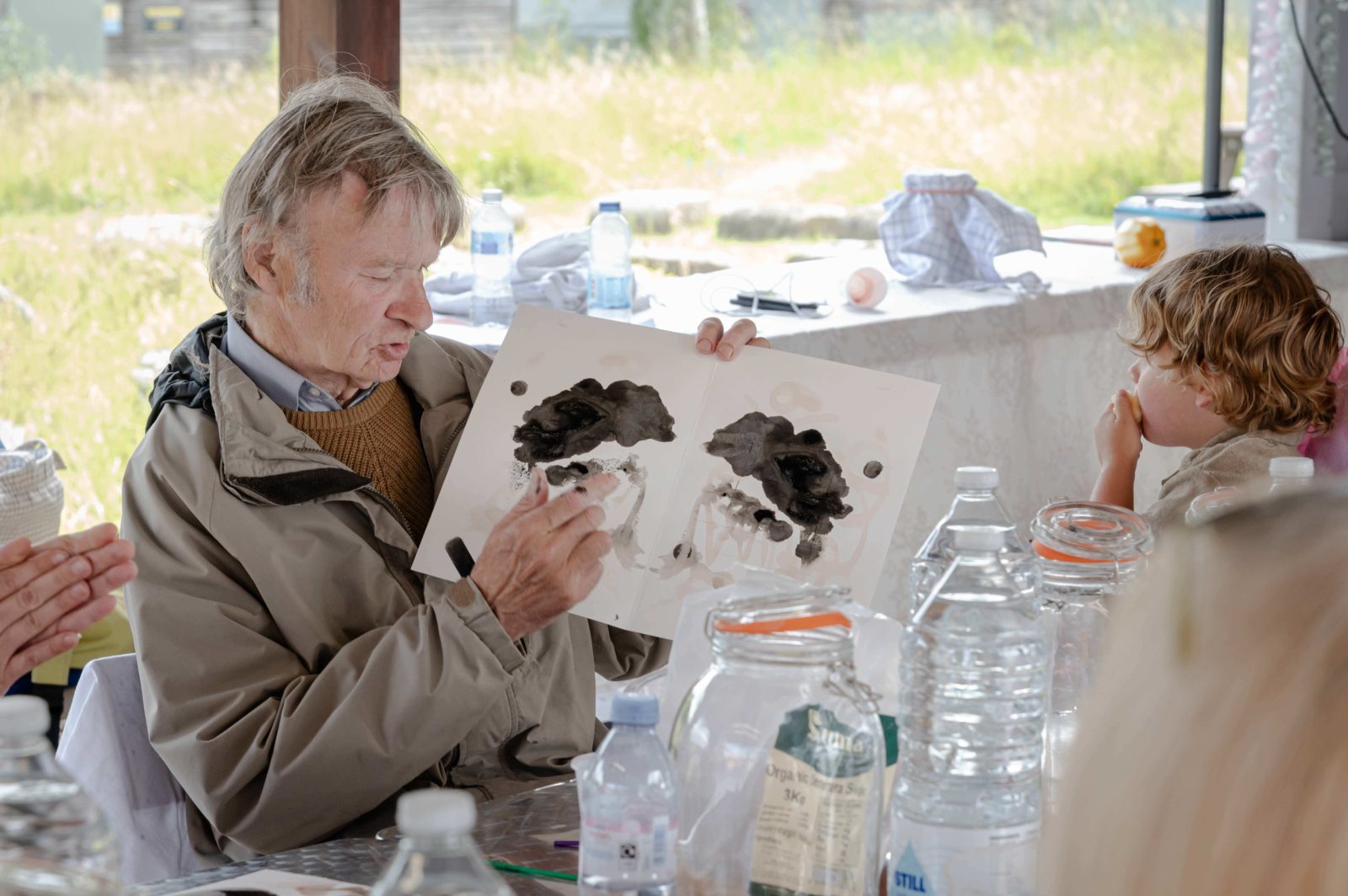 A man presents his artwork to other people around a table