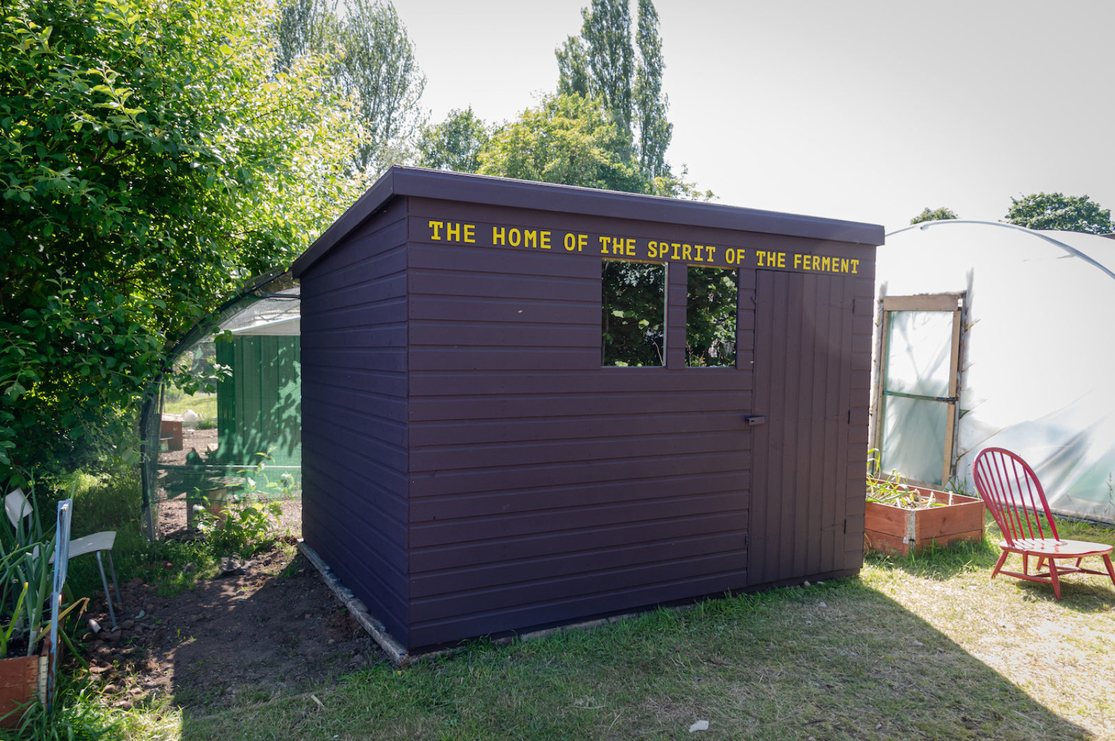 A purple shed with yellow lettering, reading "The home of the spirit of the ferment"